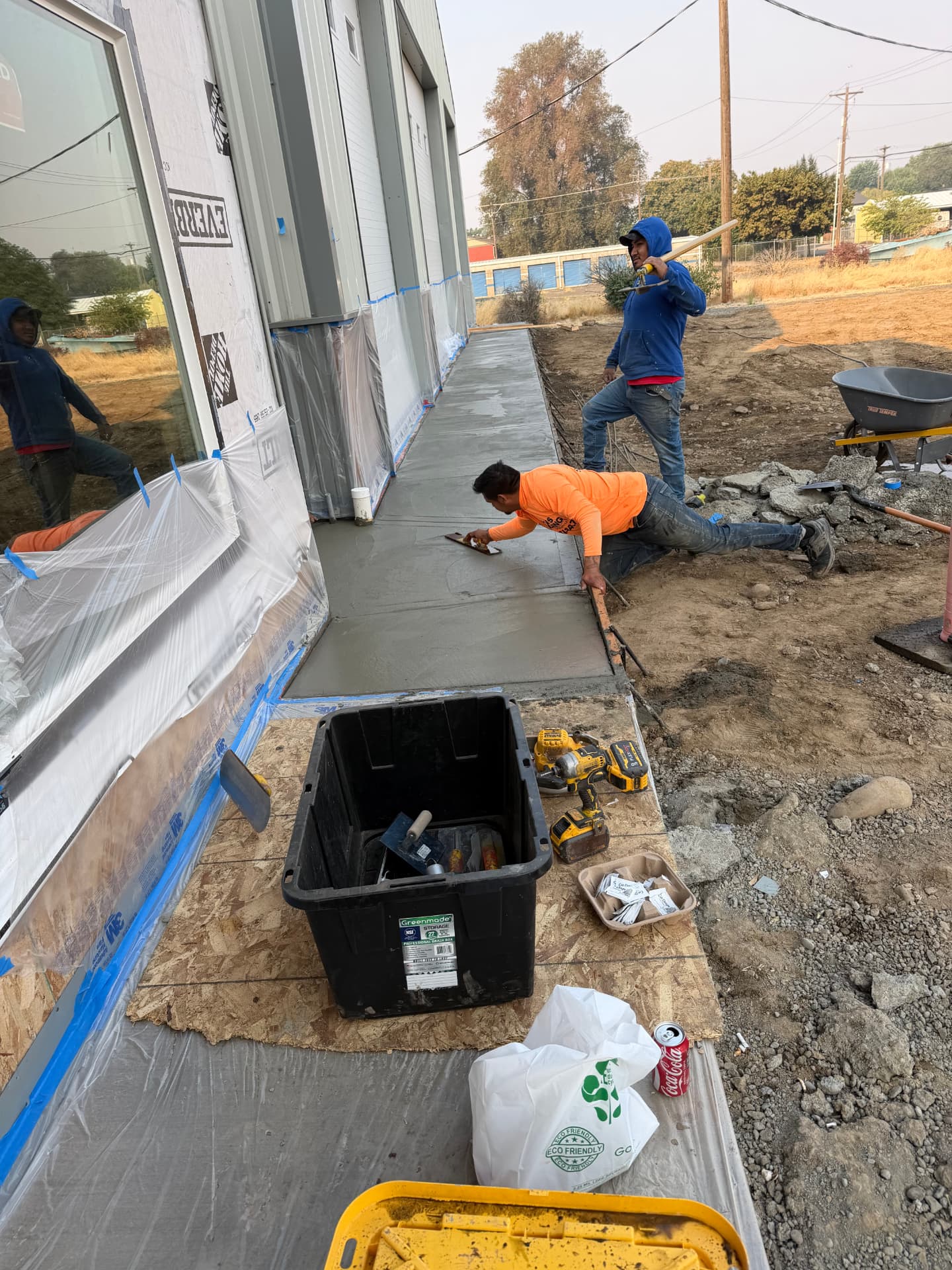 Piña's Roofing crew members hand-finishing freshly poured concrete