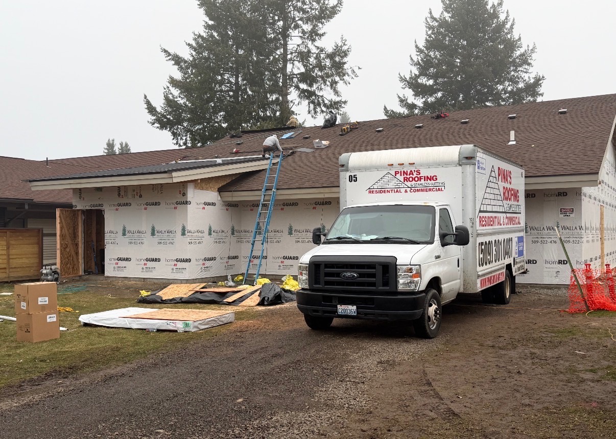 Pina's Roofing crew installing a new residential roof with company truck on site